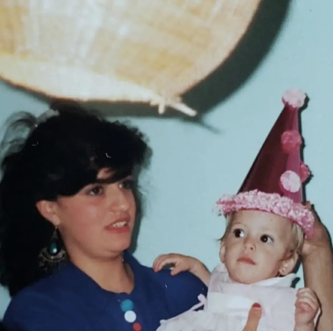 Mom putting a party hat on her daughter