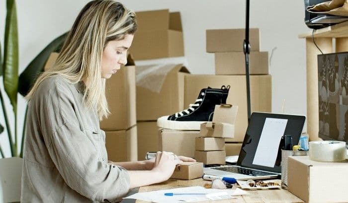 Woman with laptop and boxes