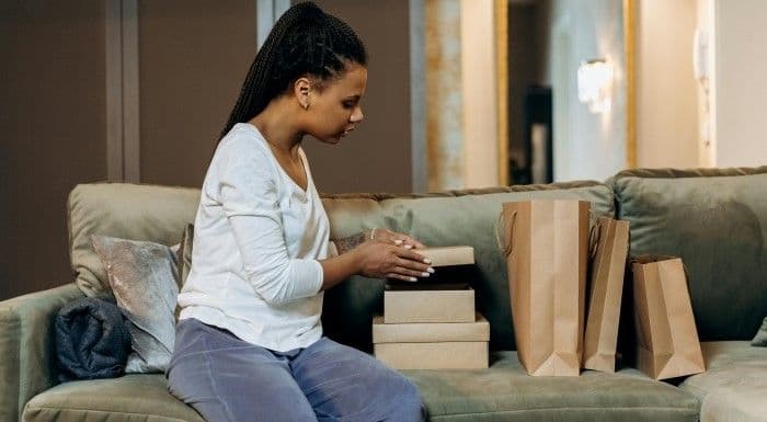 Woman holding shipping boxes and bags